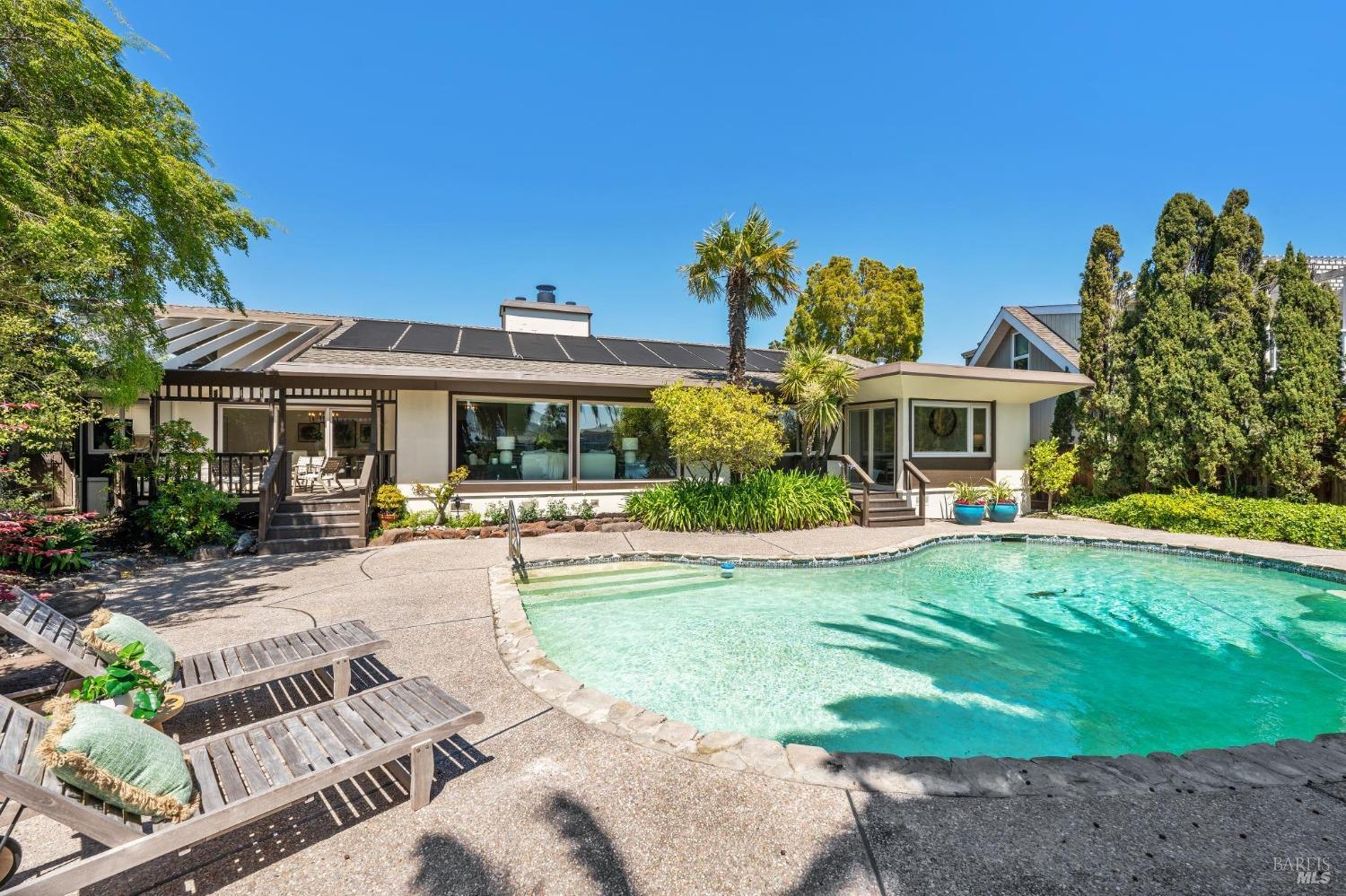 a front view of a house with swimming pool having outdoor seating