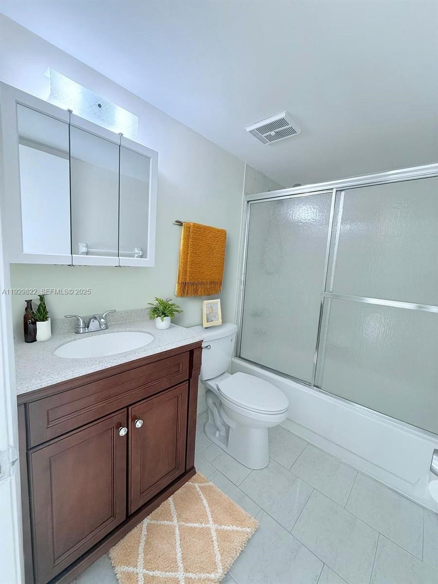 2055 Southwest 122nd Avenue, Unit 415 Miami, FL 33175 - Photo 11 of 13 a bathroom with a granite countertop sink toilet and shower