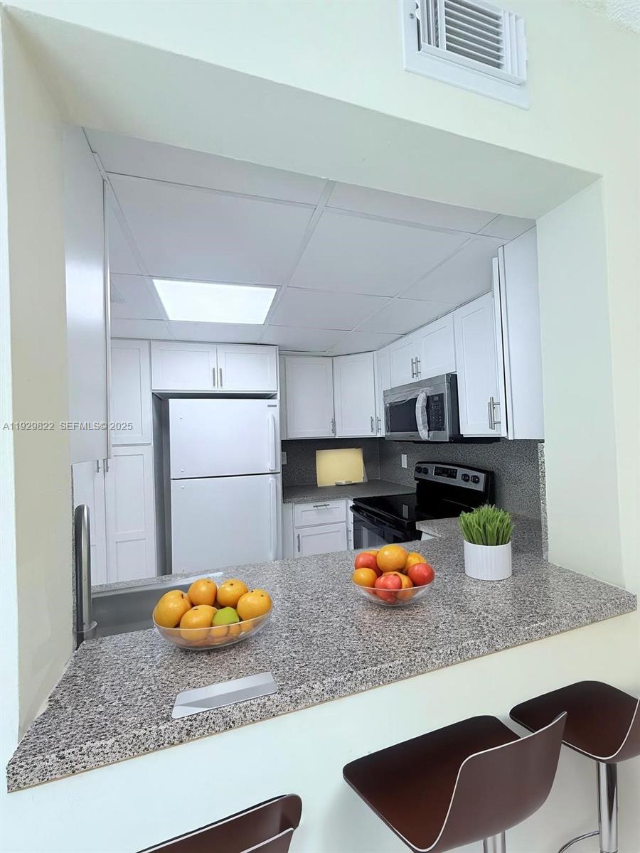 2055 Southwest 122nd Avenue, Unit 415 Miami, FL 33175 - Photo 5 of 13 a kitchen with a refrigerator and a sink