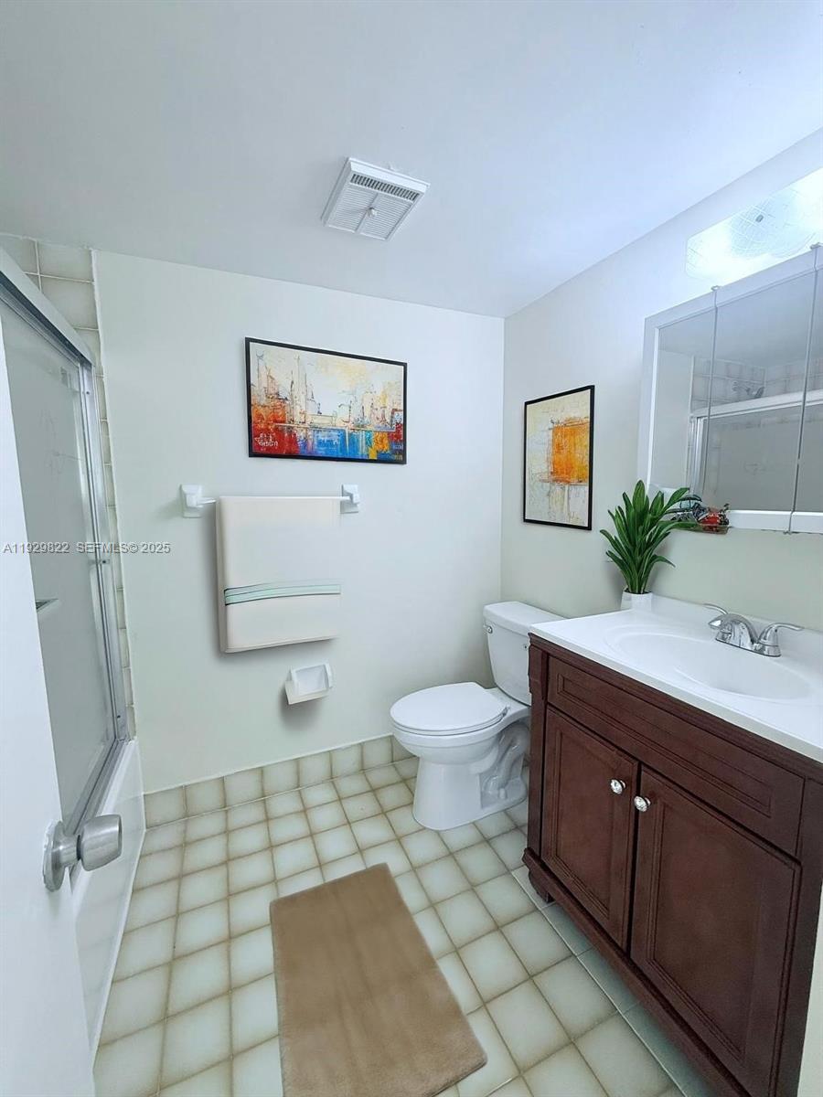 2055 Southwest 122nd Avenue, Unit 415 Miami, FL 33175 - Photo 8 of 13 a bathroom with a toilet sink and mirror
