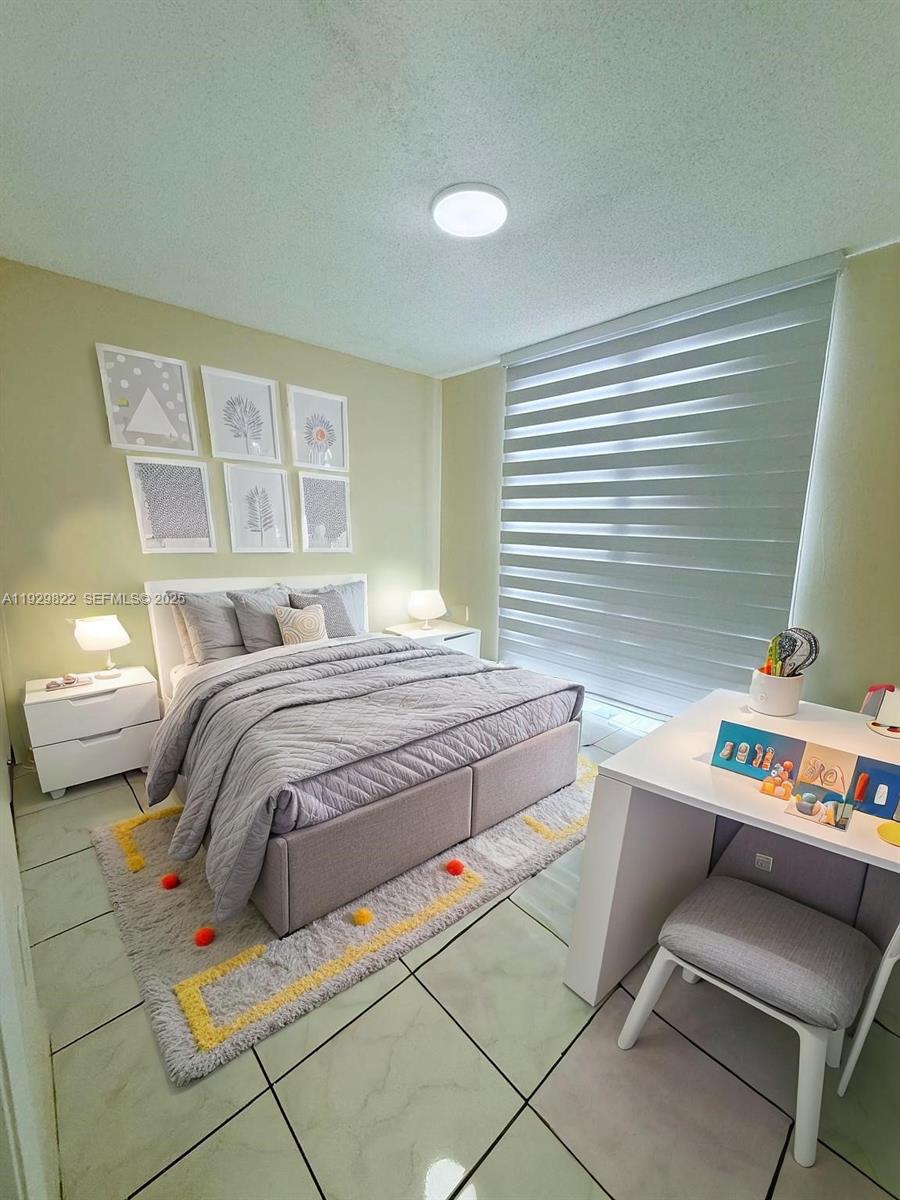 2055 Southwest 122nd Avenue, Unit 415 Miami, FL 33175 - Photo 9 of 13 a bedroom with a bed and a desk