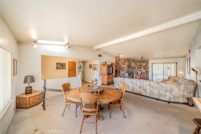 a living room with furniture and a dining table with wooden floor