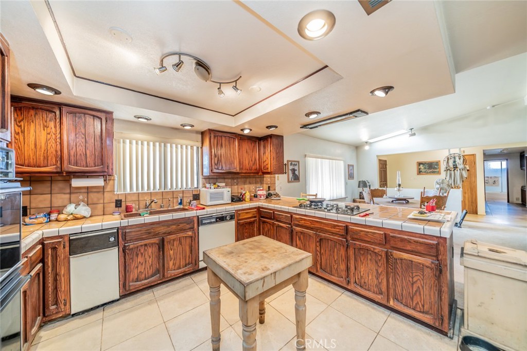 18080 Manitou Road Apple Valley, CA 92307 - Photo 16 of 43 a kitchen with a sink a stove and cabinets