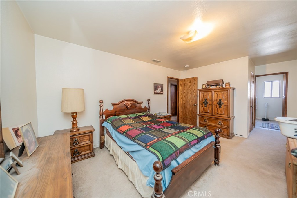 18080 Manitou Road Apple Valley, CA 92307 - Photo 19 of 43 a bedroom with a bed and wooden floor