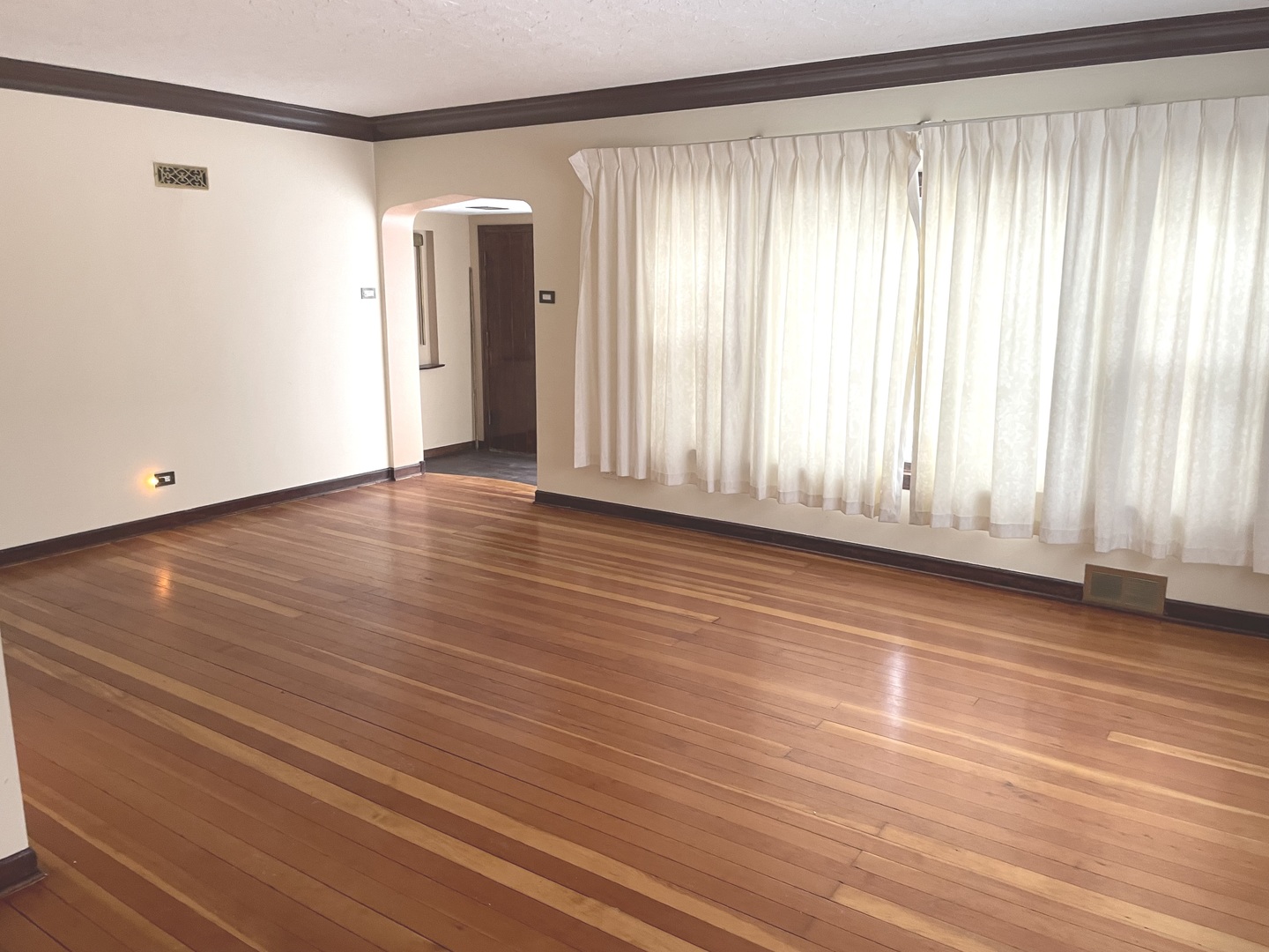 Undisclosed Address La Grange Park, IL 60526 - Photo 4 of 15 an empty room with wooden floor and windows with curtains view