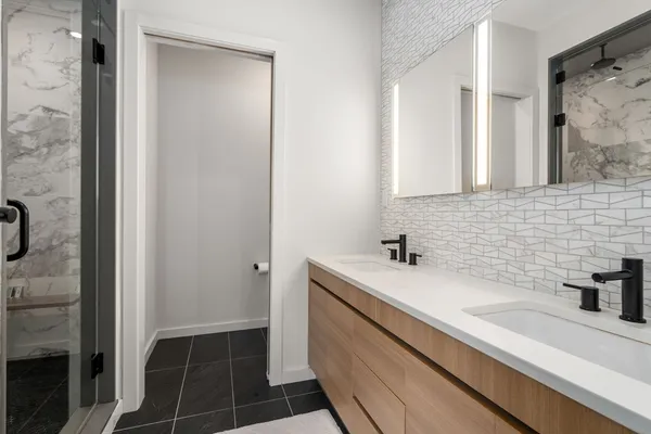 a bathroom with a sink a toilet and shower