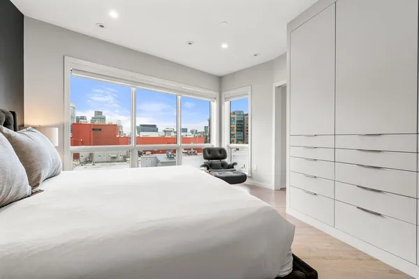 a bedroom with a bed and large windows