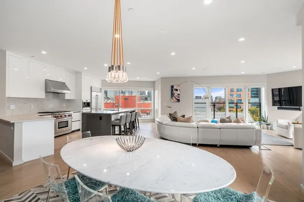 a dining room with furniture a chandelier and kitchen view
