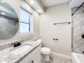 a bathroom with a granite countertop sink toilet and shower
