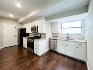 a kitchen with granite countertop white cabinets and white appliances