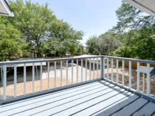 a view of balcony with wooden floor and fence