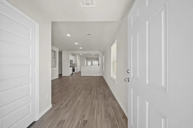 a view of a hallway with wooden floor and staircase