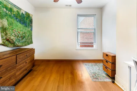 a living room with wooden floor and window