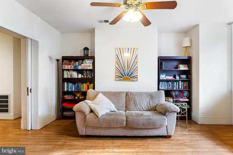 a living room with furniture and painting on the wall