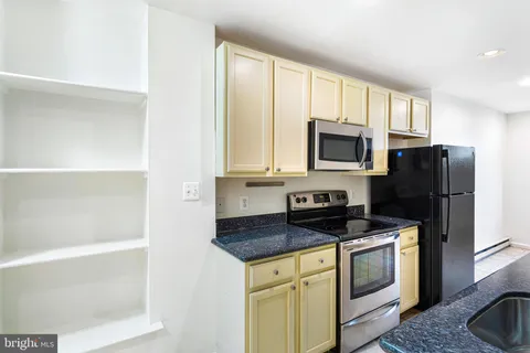 a kitchen with granite countertop a sink and cabinets