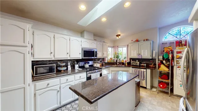 a kitchen with stainless steel appliances granite countertop a sink a stove and a microwave