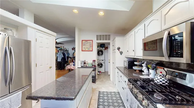 a kitchen with stainless steel appliances granite countertop a stove refrigerator and a sink