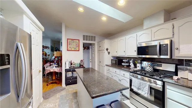 a kitchen with stainless steel appliances granite countertop a refrigerator stove and sink