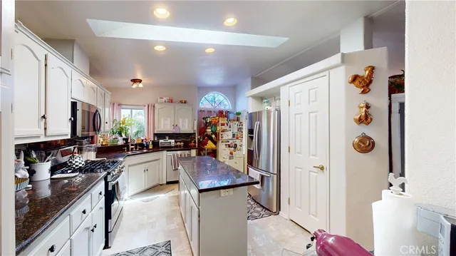 a kitchen with stainless steel appliances granite countertop a refrigerator a sink and a stove