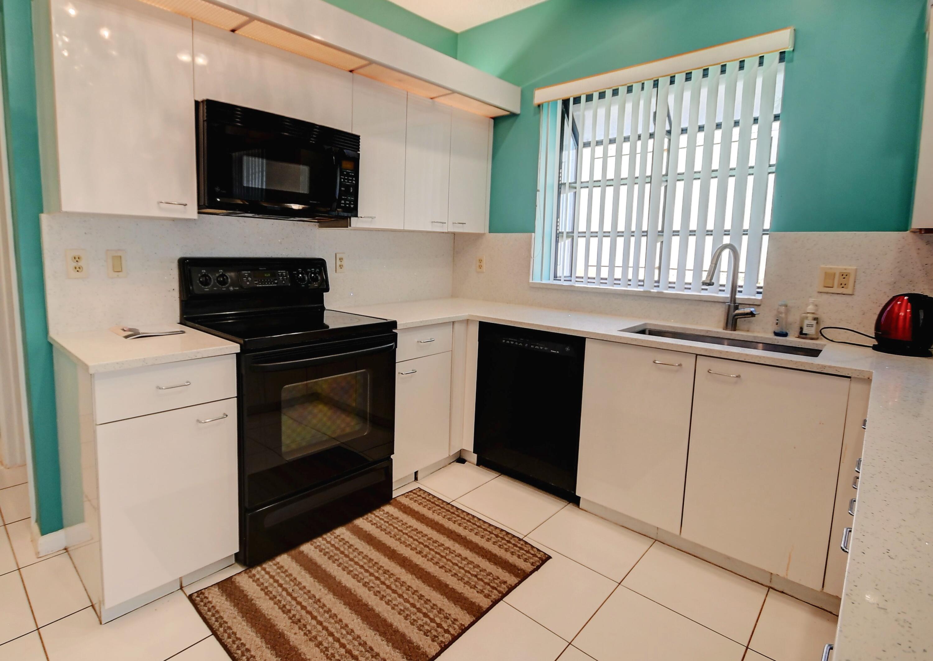 19356 Cherry Hills Terrace Boca Raton, FL 33498 - Photo 4 of 22 a kitchen with a sink stove and microwave