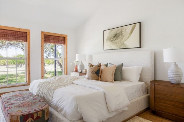 a bedroom with a bed and a lamp next to a window