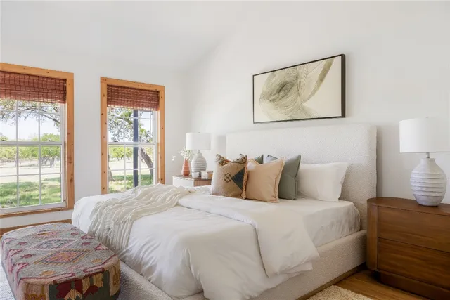 a bedroom with a bed and a lamp next to a window
