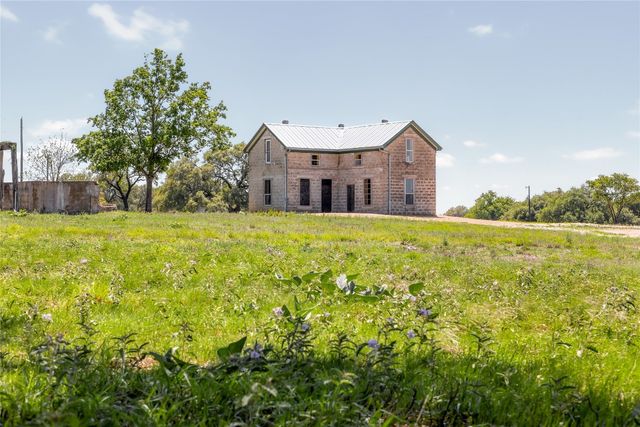 a large house with a big yard and large trees