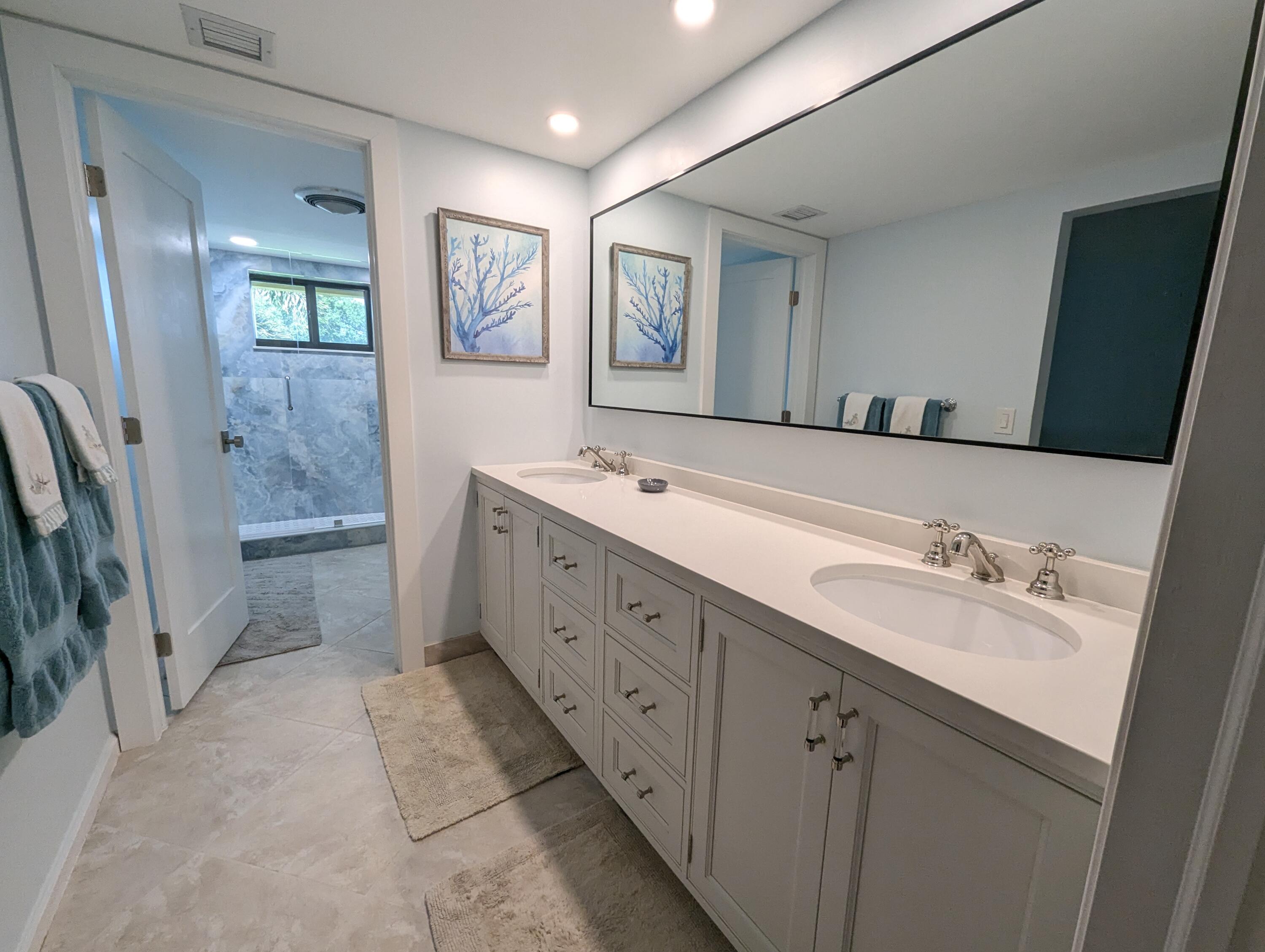 17081 Waterbend Drive, Unit 228 Jupiter, FL 33477 - Photo 13 of 21 a spacious bathroom with a double vanity sink a mirror and a shower