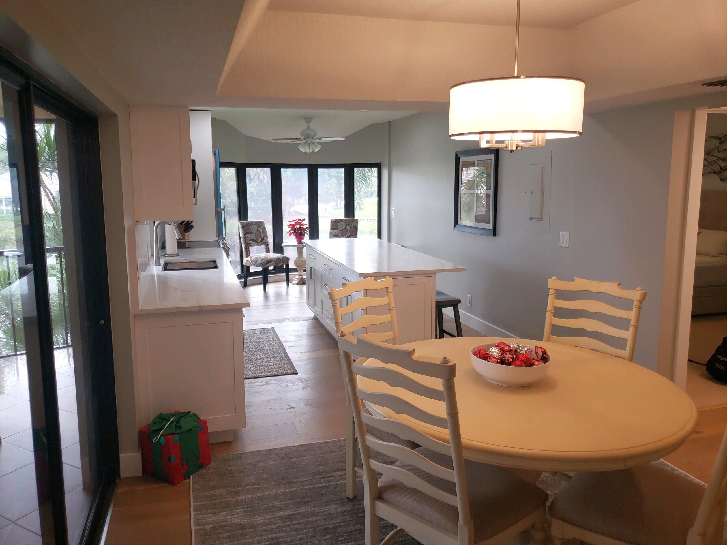 17081 Waterbend Drive, Unit 228 Jupiter, FL 33477 - Photo 7 of 21 a view of a dining room with furniture wooden floor and chandelier