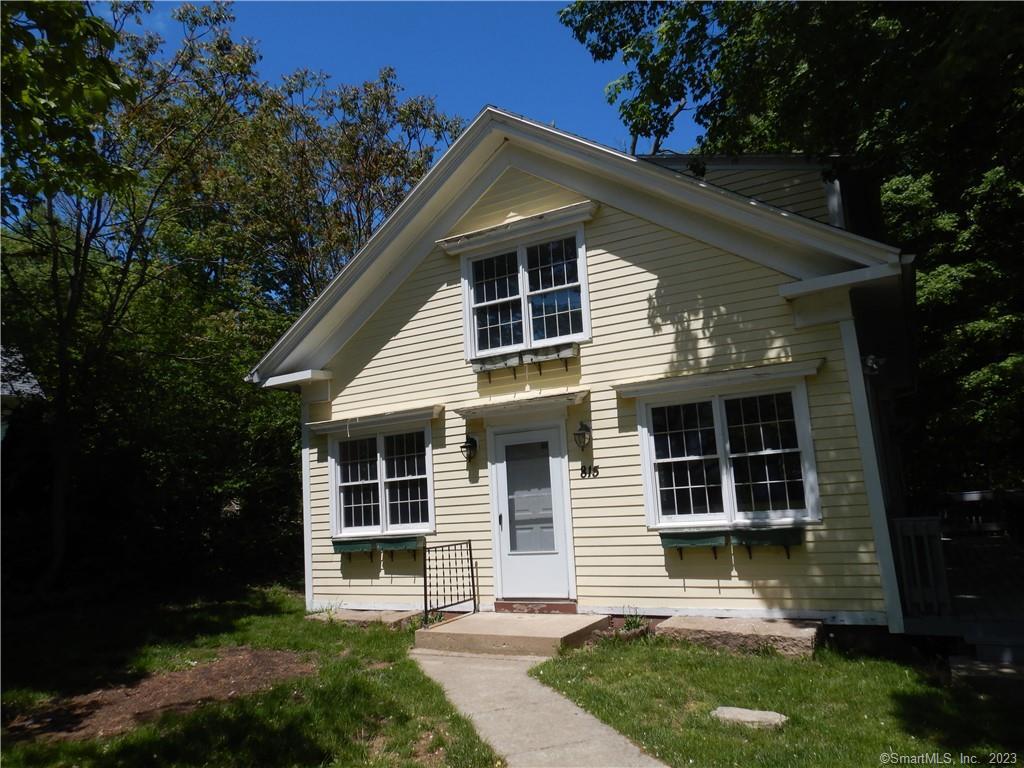 a front view of a house with a yard and green space
