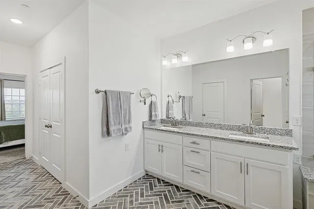 a bathroom with a granite countertop sink a mirror and shower