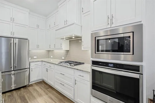 a kitchen with stainless steel appliances white cabinets a stove and a refrigerator