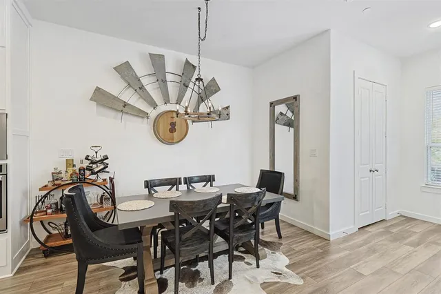 a view of a dining room and livingroom with furniture wooden floor a chandelier