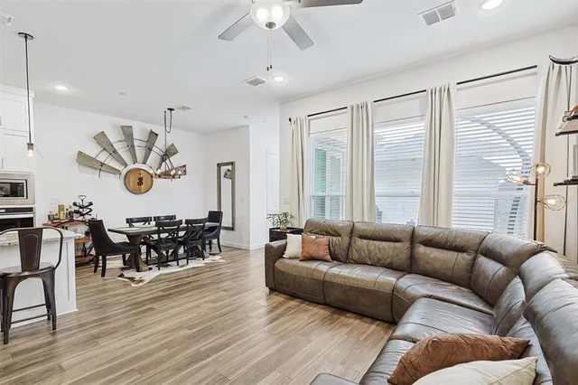 a living room with furniture kitchen view and a large window