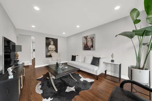 a living room with furniture a chandelier and a potted plant