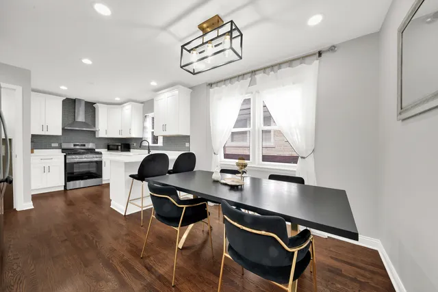 a kitchen with a dining table chairs and a refrigerator