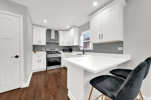 a kitchen with granite countertop white cabinets and white appliances