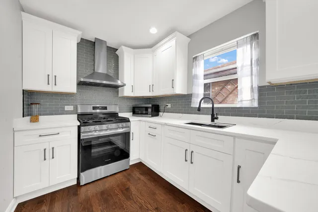 a kitchen with white cabinets sink and appliances