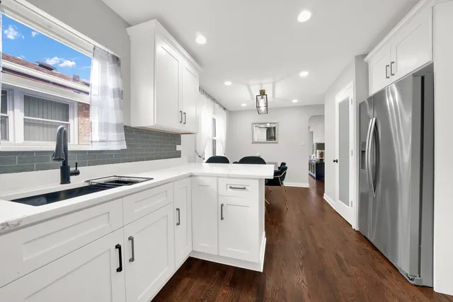 a kitchen with white cabinets and stainless steel appliances