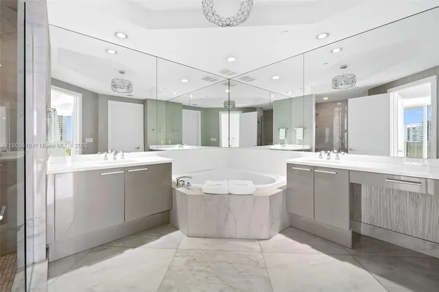 a bathroom with a tub a sink shower and mirror