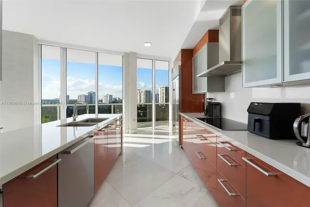 a large kitchen with stainless steel appliances a refrigerator and a sink