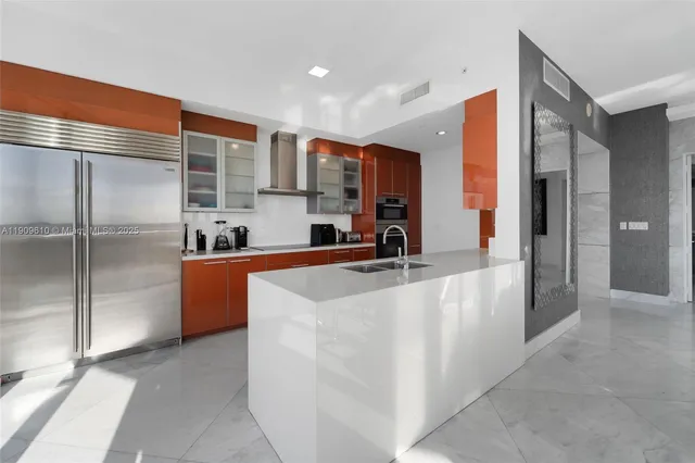 a kitchen with kitchen island stainless steel appliances a sink stove and refrigerator