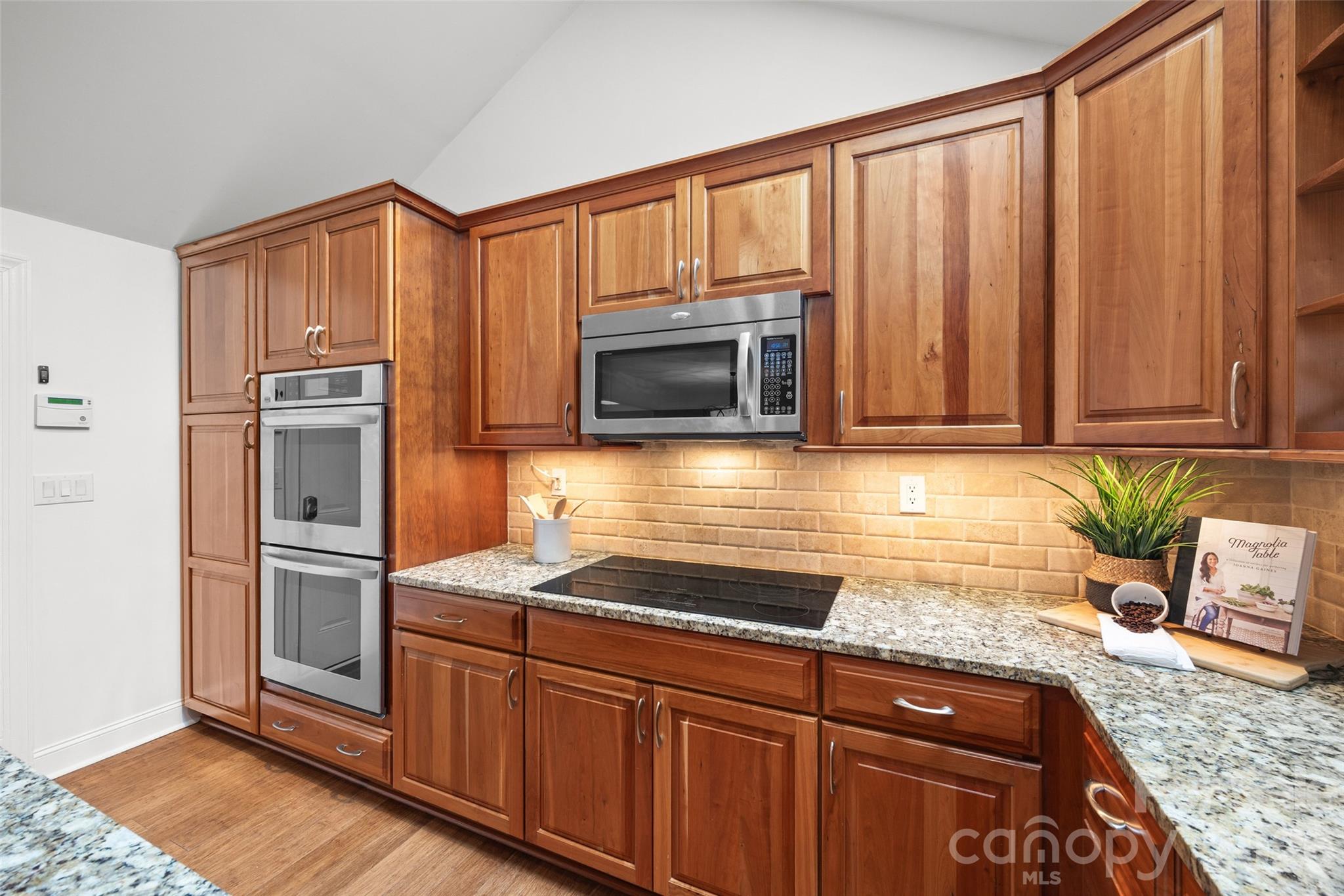 3320 Tilley Morris Road Matthews, NC 28105 - Photo 19 of 48 a kitchen with granite countertop stainless steel appliances a stove a sink and a microwave