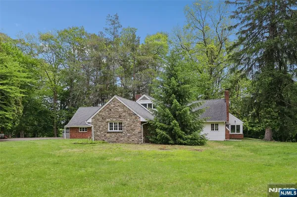 a front view of a house with a yard and trees
