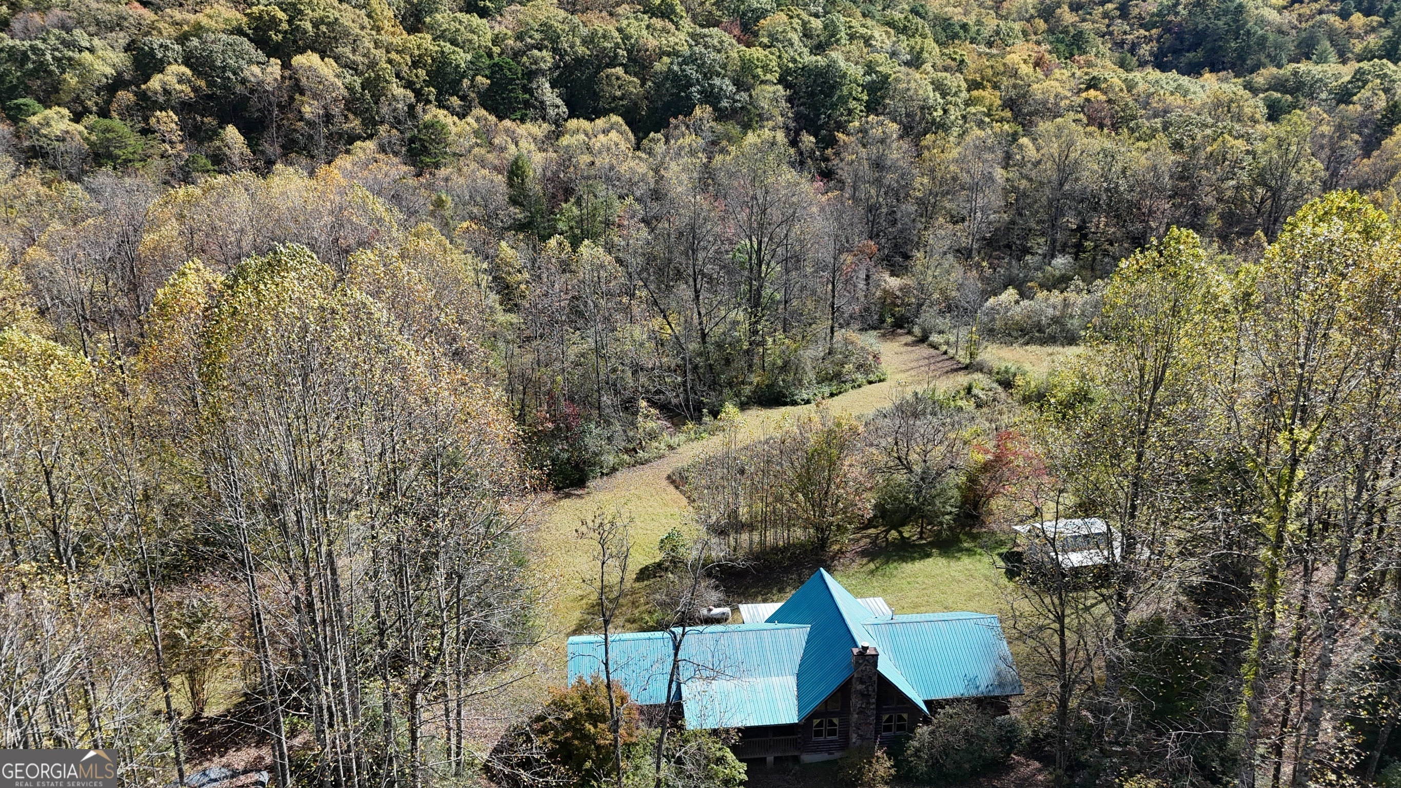 an aerial view of a house with a yard and lake view
