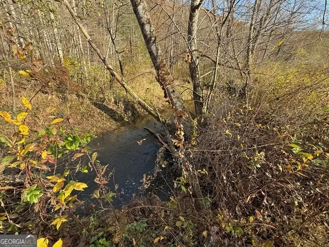 a view of a patio with table and chairs a barbeque with wooden floor and roof