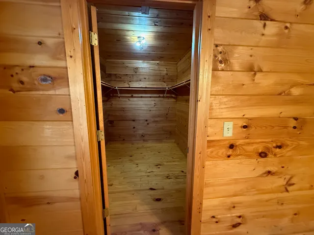 a view of a kitchen with kitchen island a stove a refrigerator wooden floor and a floor to ceiling window