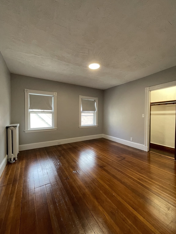 71 Mayfield Street, Unit 2 Boston, MA 02125 - Photo 21 of 33 an empty room with wooden floor and windows