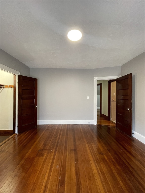 71 Mayfield Street, Unit 2 Boston, MA 02125 - Photo 23 of 33 an empty room with wooden floor and closet and window