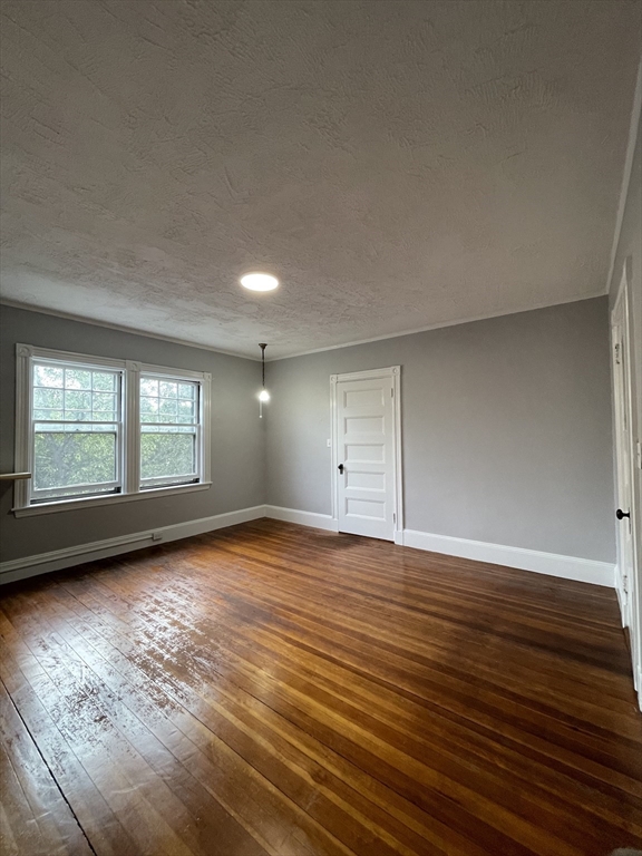 71 Mayfield Street, Unit 2 Boston, MA 02125 - Photo 31 of 33 an empty room with wooden floor and windows